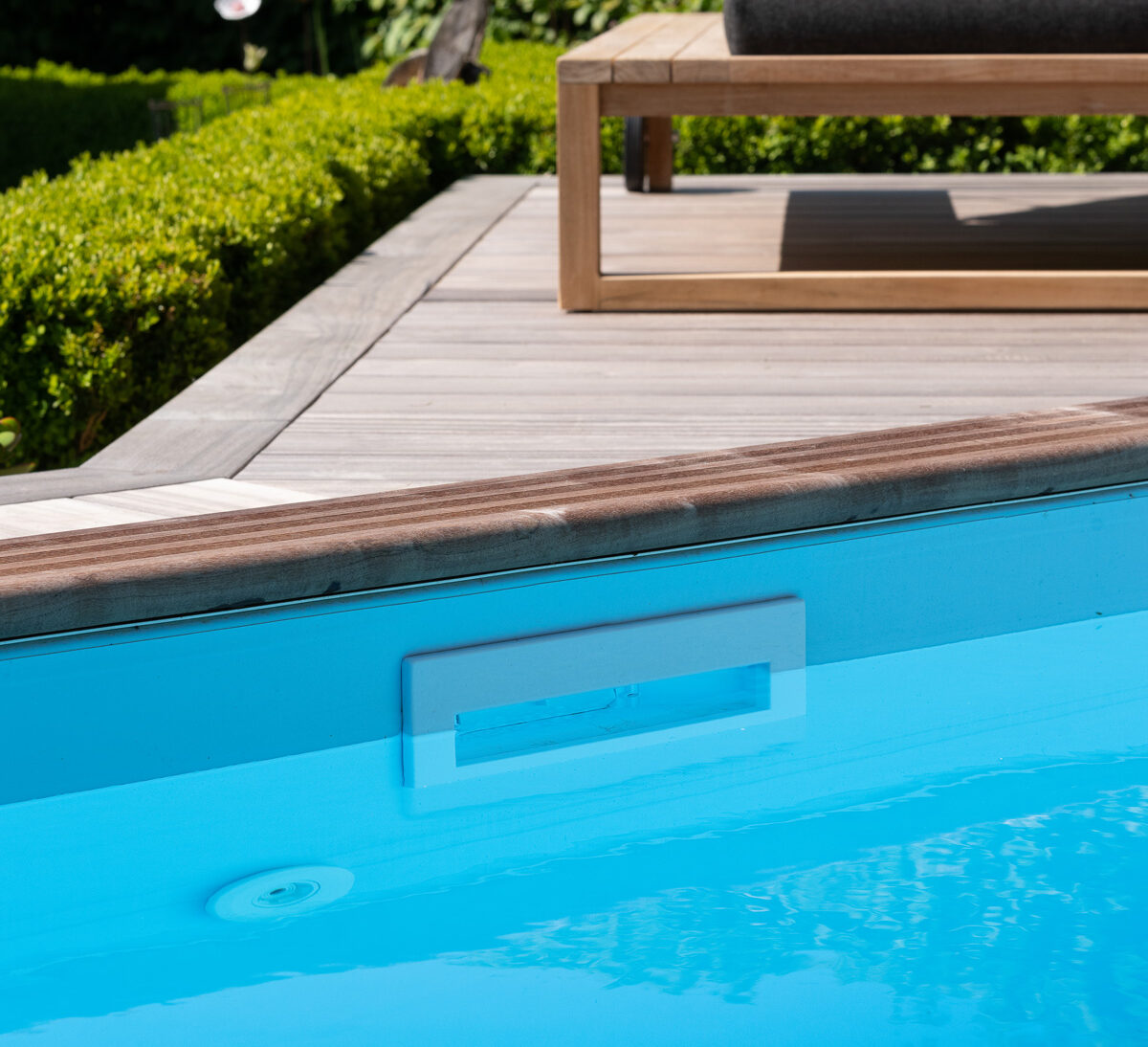 Detail van een houten zwembad met geïntegreerde skimmer en filteropening voor efficiënt en eenvoudig onderhoud