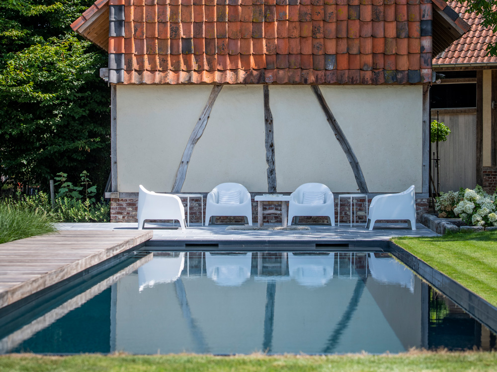 Polypropyleen zwembad in houten terras met ligstoelen en felblauw water