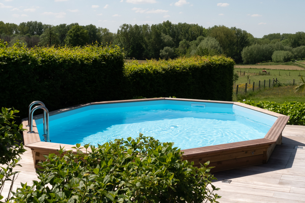 Houten zwembad met terras en zicht op het landschap voor een warme, landelijke uitstraling.