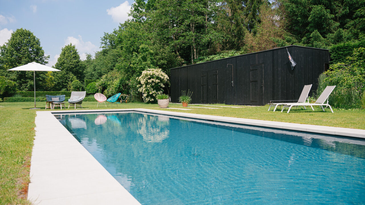 Strak ingebouwd zwembad in een groene tuin, een voorbeeld van een duurzame zwembadoplossing met hogere aanlegkost