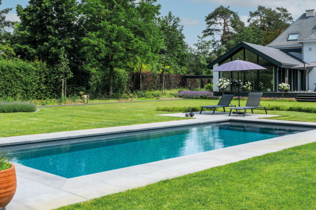 Strak vinylester monoblok zwembad in moderne tuin met naadloze afwerking.