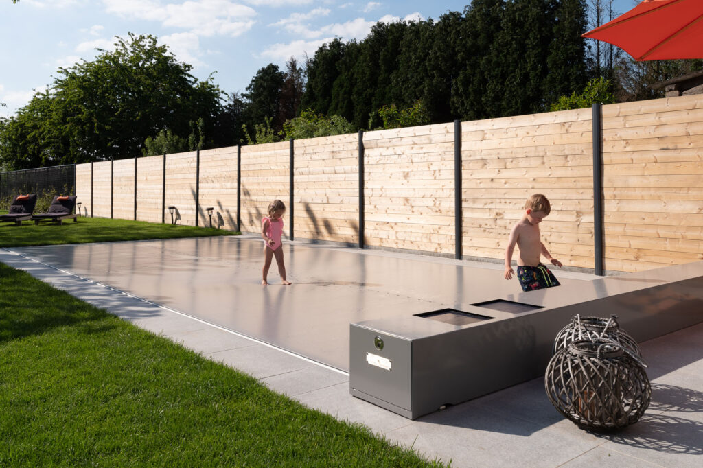 Zwembad met gesloten afdekking in familietuin, een investering die energie- en onderhoudskosten helpt beperken.