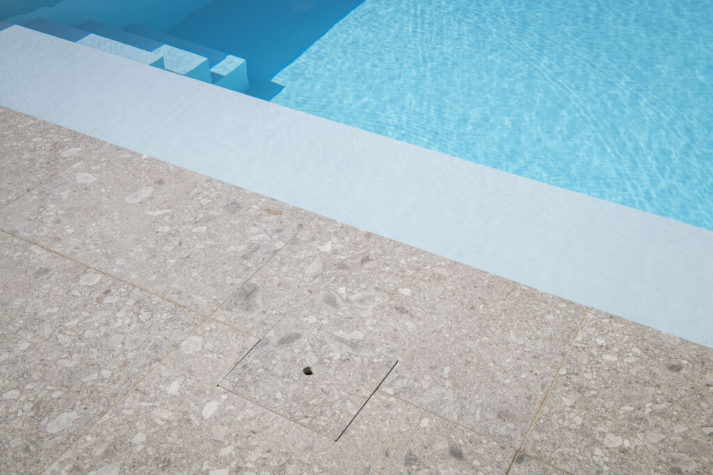 Detail van zwembadrand en waterlijn, waarbij afwerking een belangrijke invloed heeft op de totale kost van het zwembad