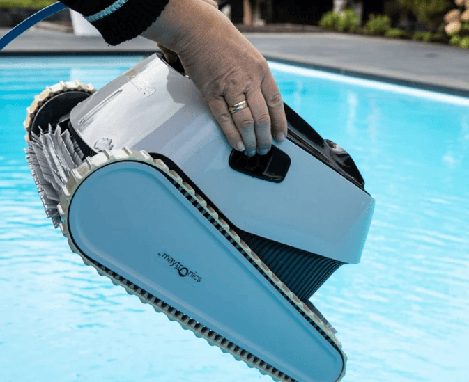 Zwembadrobot van Maytronics uit het water geheven na het reinigen van de zwembadboden.