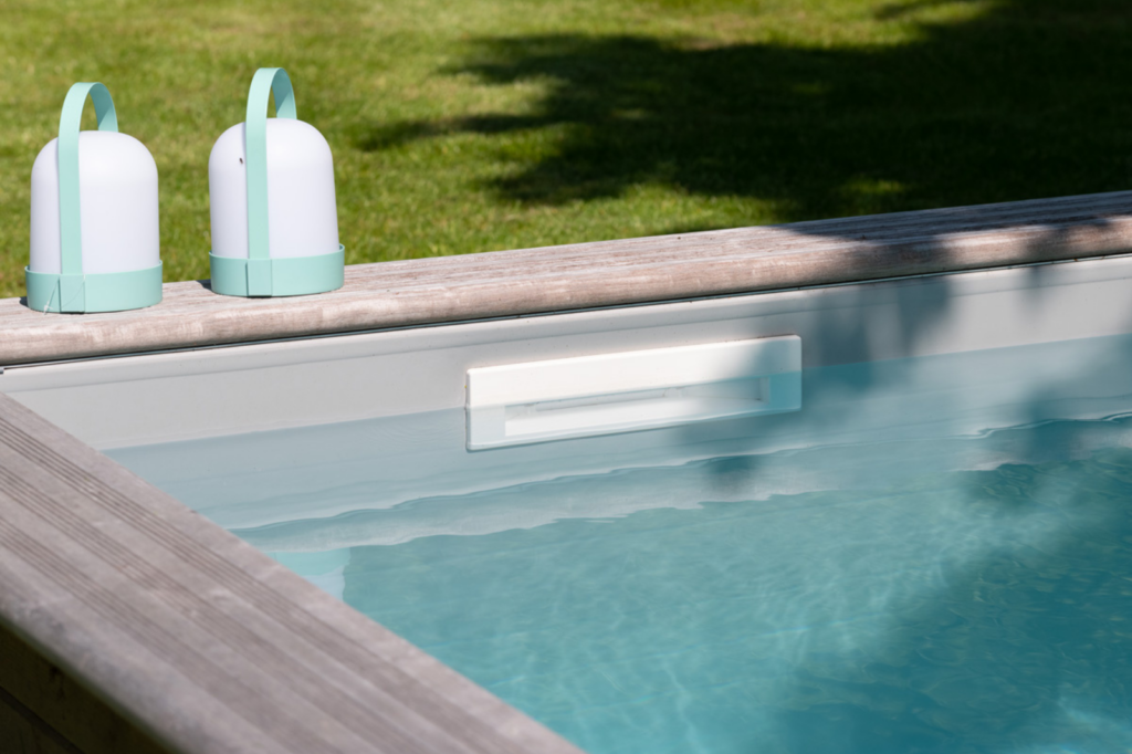 Hoek van een houten zwembad met helder water en een witte skimmer die het wateroppervlak schoon houdt