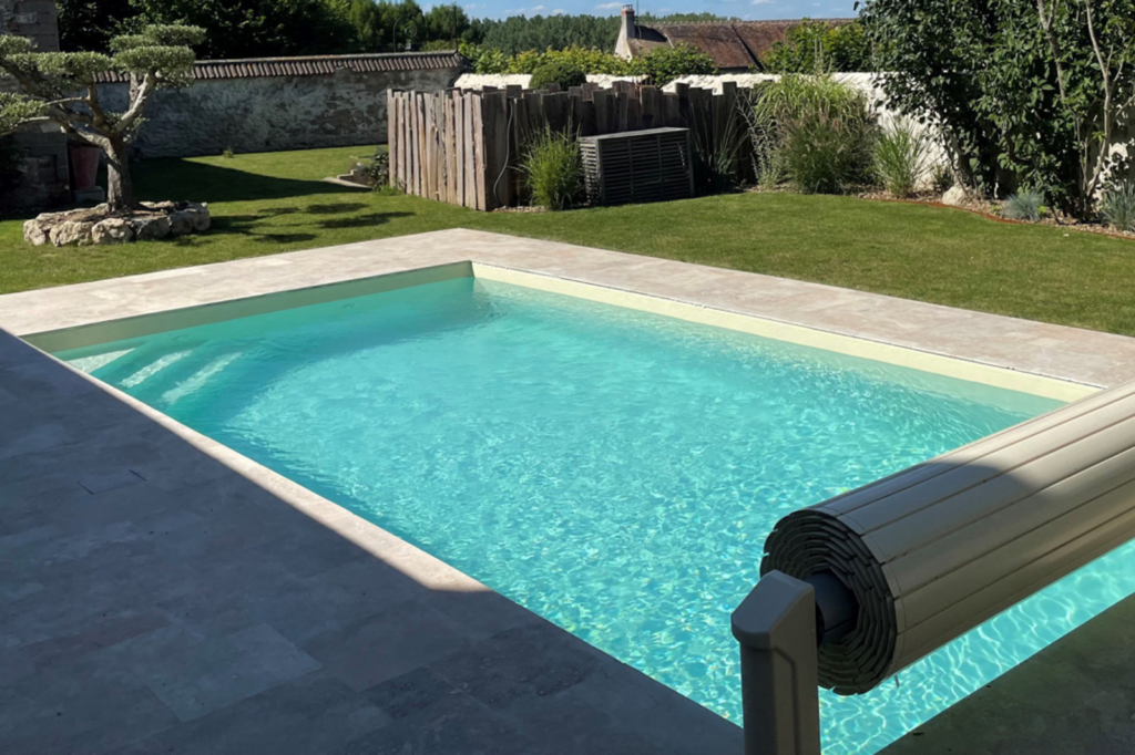modulair-infiniteau-zwembad-liner Infiniteau zwembad met liner-afwerking en oprolbaar zwembadrolluik in een natuurstenen tuin.